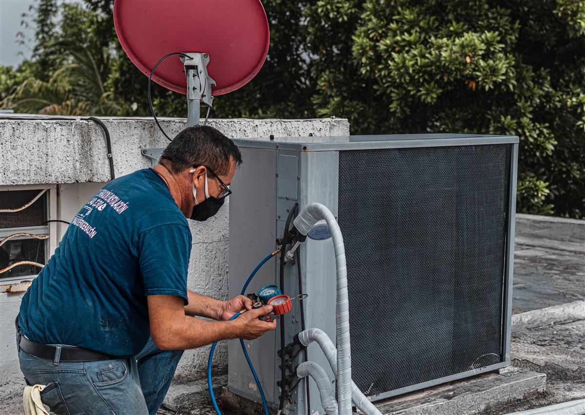 Technician completing HVAC repair with service gauges